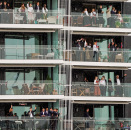 Folk vinker til Kongeskipet fra balkonger på Tjuvholmen. Foto: Lise Åserud / NTB